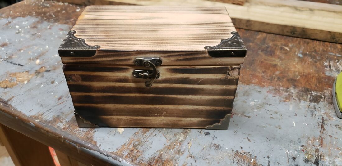 Small wooden box with a burned finish and metal latch