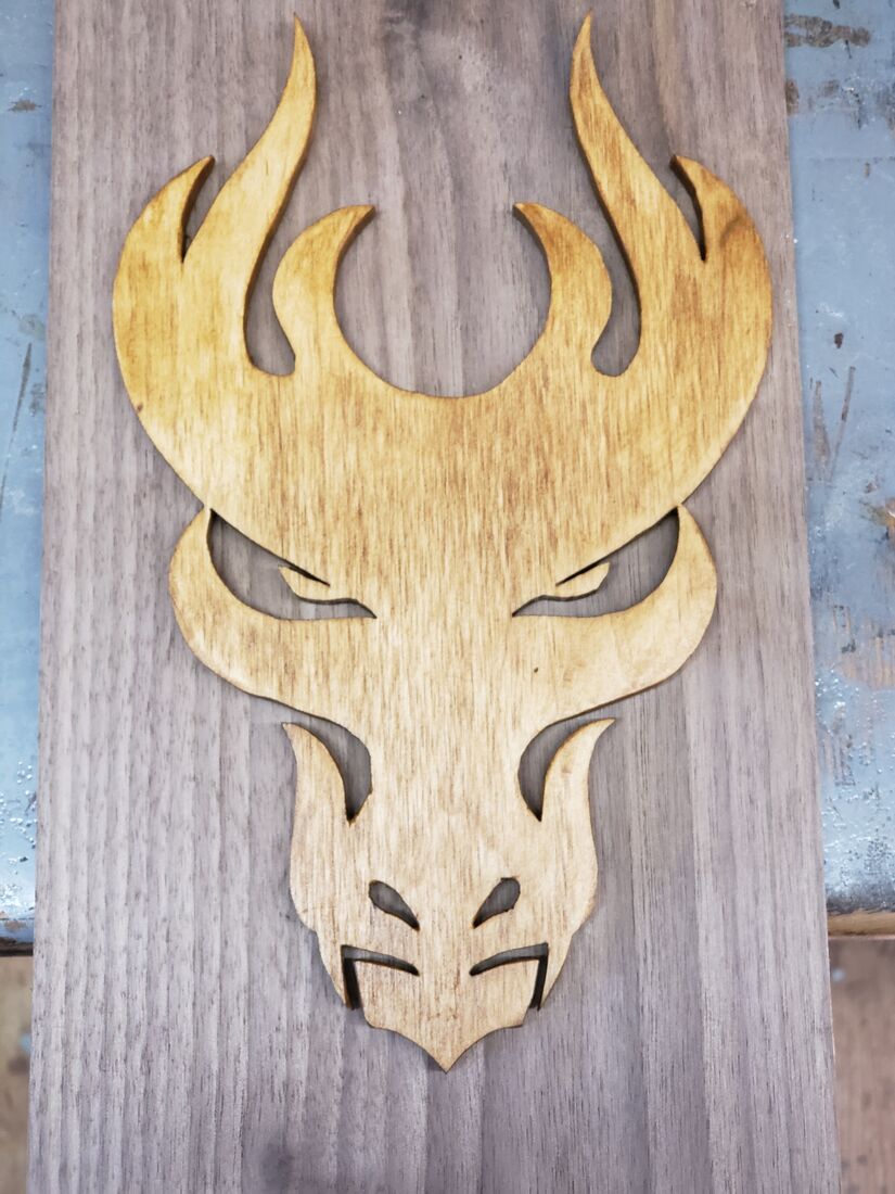 Light wood dragon head with flame horns on a dark board