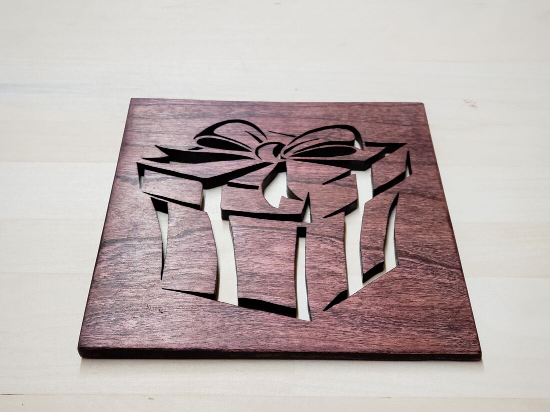 Wrapped gift with a bow cut into a reddish wood panel