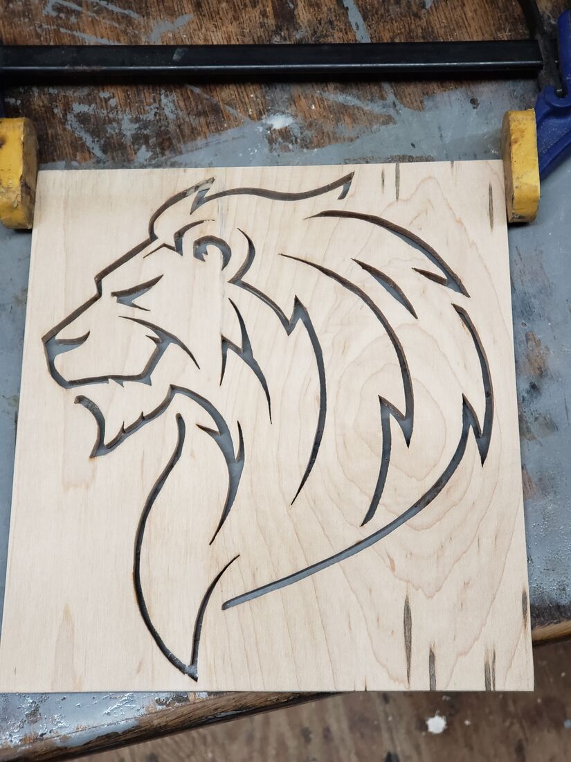 Lion head in line art cut into light wood