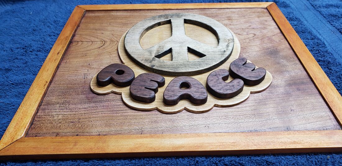 Layered peace sign and the word Peace in a framed panel