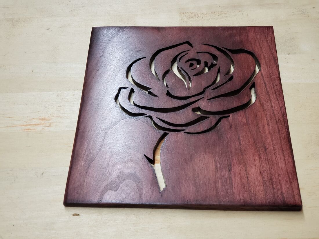 Rose cut into a reddish wood panel