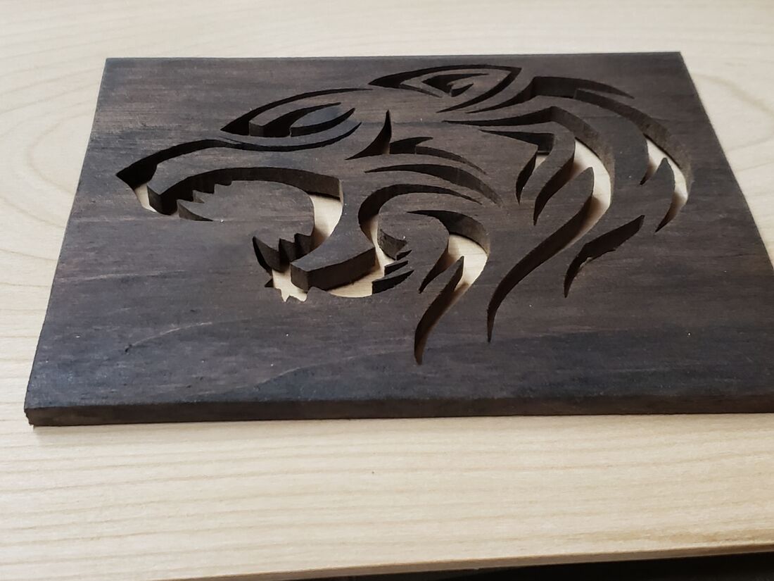 Tribal tiger head cut into dark stained wood
