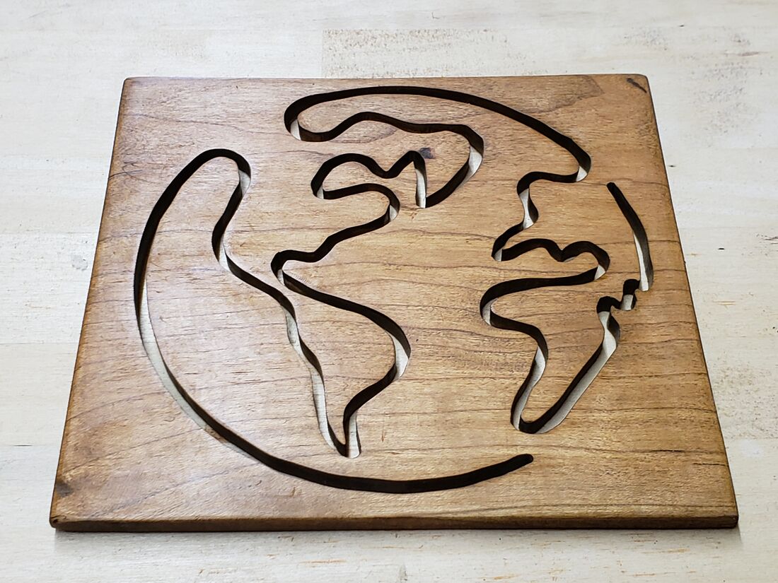 Line drawing of the globe cut into a wood panel